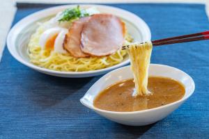 duas tigelas de comida com esparguete e carne numa mesa em Vessel Hotel Higashi Hiroshima em Higashihiroshima