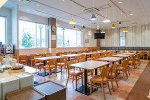 a long dining room with tables and chairs at Vessel Hotel Higashi Hiroshima in Higashihiroshima
