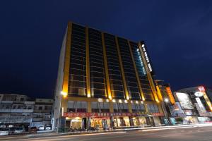 嘉义市永悦商务大饭店的夜晚城市街道上的一栋大楼