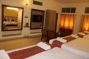 Tempat tidur dalam kamar di Kaveri Hotel Bed & Breakfast