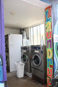 lavadero con 2 lavadoras y ventana en Pippies Beachhouse Backpackers, en Rainbow Beach