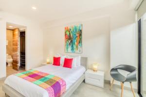 une chambre blanche avec un lit et une chaise dans l'établissement Icono Playa Condos, B307, à Playa del Carmen 17 autres photos