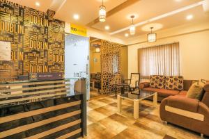een wachtkamer met een bank en een tafel bij FabHotel Frazer Suites Pulikeshi Nagar in Bangalore
