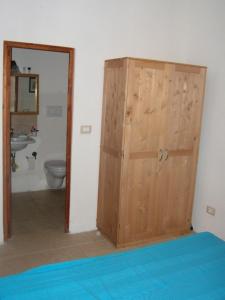 a wooden door in a bathroom with a toilet at Casa Telesio in Ostuni