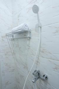 eine Dusche mit Duschkopf im Bad in der Unterkunft ratana cengkareng syariah in Jakarta