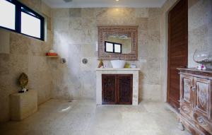 a bathroom with a sink and a mirror on the wall at Bayshore Residence in Candidasa