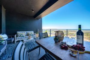 a table with a bottle of wine on top of it at 365 Sunset Self Catering Apartments in Noordhoek