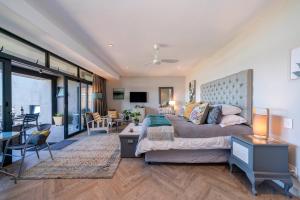 a bedroom with a large bed and a living room at 365 Sunset Self Catering Apartments in Noordhoek