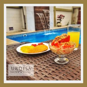 una mesa con dos platos de comida y un bol de fruta en Urdesa Suites Hotel, en Guayaquil