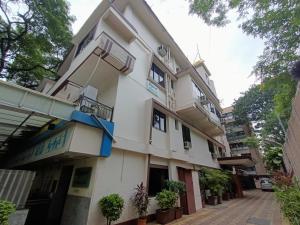 a white building with balconies and potted plants at Hotel Park View, Mumbai in Mumbai