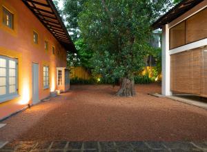 a courtyard with a tree in the middle of a building at De Saram House by Geoffrey Bawa in Colombo