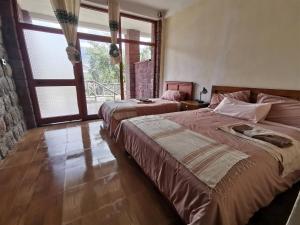 sypialnia z 2 łóżkami i dużym oknem w obiekcie Lalibela Apartments w mieście Lalibela