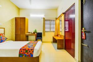 a bedroom with a bed and a desk with a chair at FabHotel Sky Bay Residency in Chennai