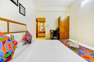 een slaapkamer met een wit bed en kleurrijke kussens bij FabHotel Sky Bay in Chennai