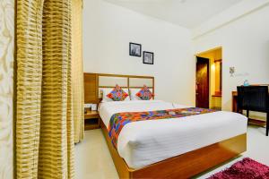 um quarto com uma cama grande num quarto em FabHotel Sky Bay em Chennai