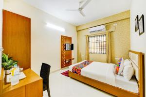 a bedroom with a bed and a desk and a table at FabHotel Sky Bay Residency in Chennai +15 photos