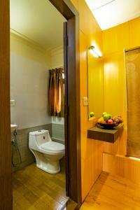 a bathroom with a toilet and a bowl of fruit at Southern Panorama Houseboats in Alleppey