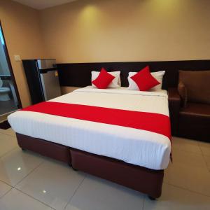 芭達雅南區的住宿－KKinn South Pattaya，一间卧室配有一张带红色枕头的大床