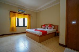 Un pat sau paturi într-o cameră la OYO 1273 Hotel Belvena