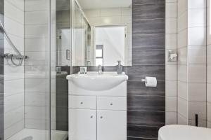 een witte badkamer met een wastafel en een douche bij River Rooms Nottingham in Nottingham