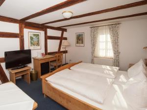 a bedroom with a large bed and a television at Hotel Engel in Rheinmunster