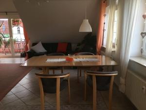 - une table et des chaises en bois dans le salon dans l'établissement Ferienwohnung Haus Albsicht, à Mössingen