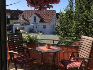 un patio con 2 sillas y una mesa en el balcón en Ferienwohnung Haus Albsicht en Mössingen