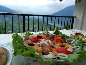 a salad with tomatoes and onions on a table at Eco Village Jasavic in Plav