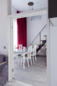 a dining room with a white table and white chairs at Premium Apartments Gallery of stories in Saint Petersburg