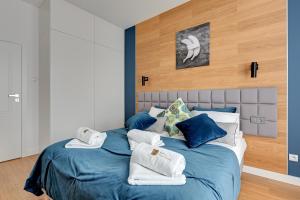 a bedroom with a blue bed with towels on it at The Maritime Suite - Luxury Botanica in Gdańsk