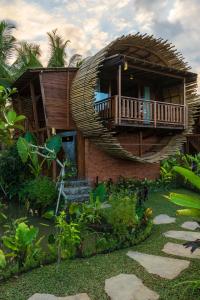 a house with a spiral staircase in a garden at Beehouse Dijiwa Ubud in Ubud