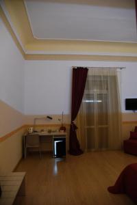 sala de estar con escritorio y ventana en B&B The Queens, en Foggia