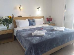 a bedroom with a bed with two towels on it at Hotel Kyma in Skala Eresou