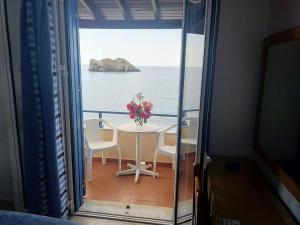 a table with a vase of flowers on a balcony at Hotel Kyma in Skala Eresou