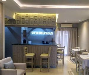 a restaurant with a bar with chairs and tables at Hotel Kyma in Skala Eresou