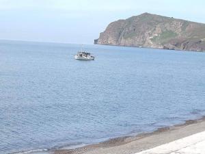 a boat in the water next to a beach at Hotel Kyma in Skala Eresou