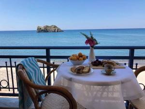 a table with a plate of food on the beach at Hotel Kyma in Skala Eresou