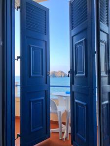 an open door with a table and a view of the ocean at Hotel Kyma in Skala Eresou