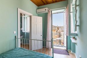 a bedroom with a bed and a large window at St Spyridon Cosy Apartment by Konnect, Old Corfu Town in Corfu Town