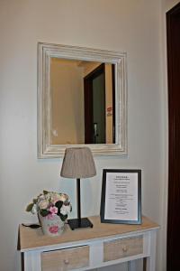 里斯本的住宿－羅馬旅遊公寓，墙上的桌子,上面有灯和镜子