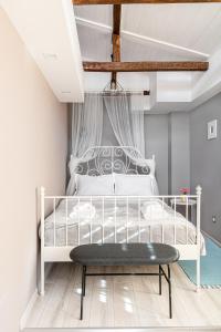 a bedroom with a white bed with a wooden floor at The Red Roof House in Plovdiv