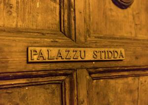 una porta di legno con un cartello che dice "palaia studia" di Palazzu Stidda Catania a Catania