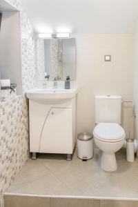 a white bathroom with a toilet and a sink at The Red Roof House in Plovdiv +25 photos