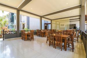 a dining room with wooden tables and chairs at Grand Senggigi Hotel in Senggigi 