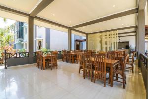 a dining room with wooden tables and chairs at Grand Senggigi Hotel in Senggigi