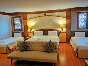 a large bedroom with two beds and a couch at Sakol Hotel in Hat Yai +47 photos