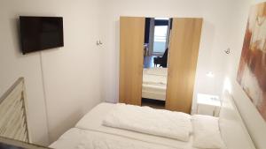 Habitación pequeña con cama y espejo. en Vier Jahreszeiten Haus 2 Whg 46, en Großenbrode