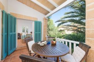 a wooden table and chairs on a balcony at Villa Herdain in Alcudia