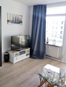 a living room with a flat screen tv and a window at Vier Jahreszeiten Haus 2 Whg 73 in Großenbrode