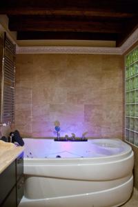 a white tub in a bathroom with a wall at Casa Rural Madre Pepa in Carreña de Cabrales